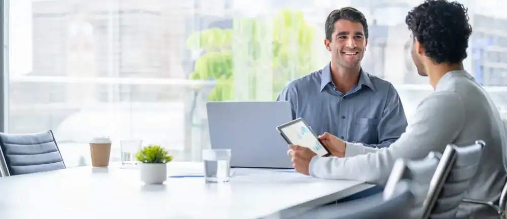 Fractional CMO reviewing marketing analytics and growth strategy with CEO in consultation meeting.